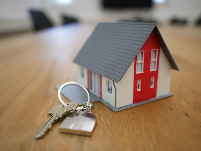 key ring sitting next to a miniature house on a table.