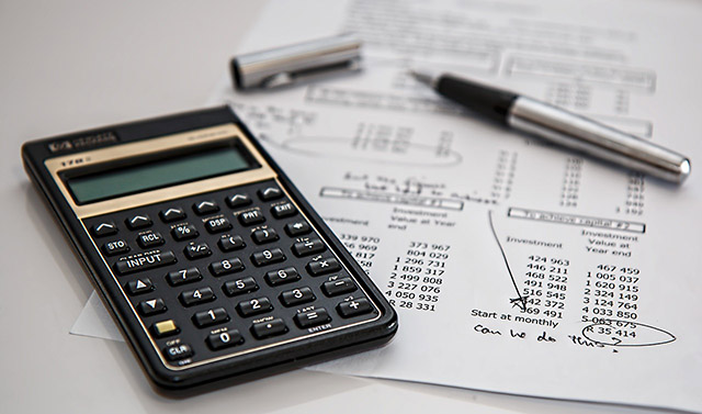 calculator and pen on a financial document.